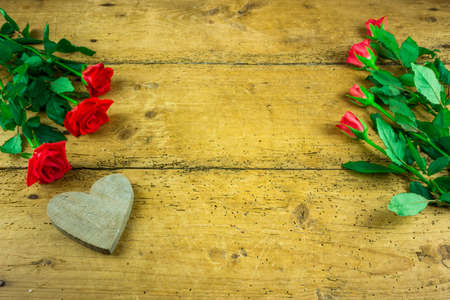 Red roses with a heart on a wooden boardの写真素材