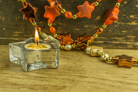 Christmas decoration with star garlands and candles on a rustic boardの写真素材