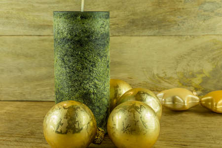 Christmas decoration - Green candles with golden christmas balls on a rustic boardの写真素材