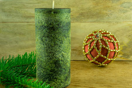 Christmas decoration - Green candles with Christmas balls and fir branch on a rustic boardの写真素材