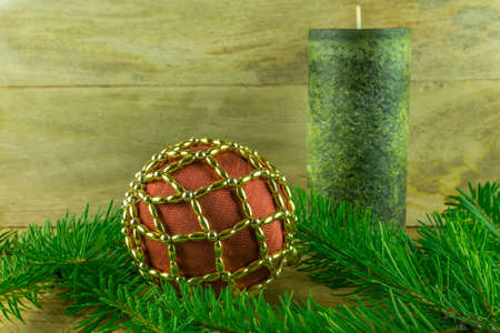 Christmas decoration - Green candles with Christmas balls and fir branch on a rustic boardの写真素材