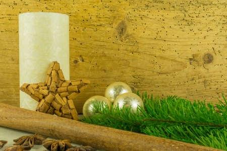 Christmas decoration with cinnamon stars, candles, Christmas balls and pine branchesの写真素材