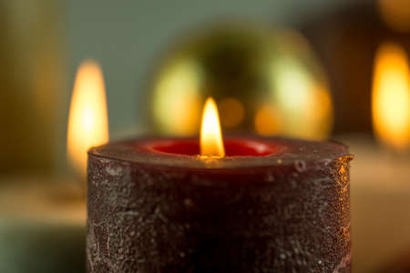 Many burning candles in different colors with a blurry backgroundの写真素材
