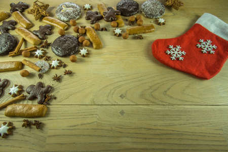 Christmas decoration on a rustic wooden board with gingerbread, candles, christmas ballsの写真素材