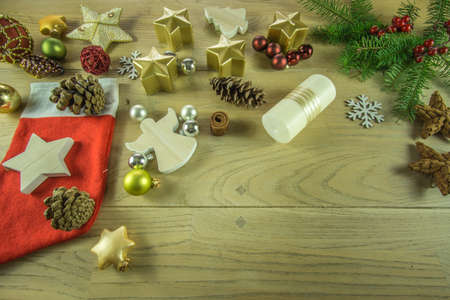 Christmas decoration on a rustic wooden board with cinnamon star, candles, christmas ballsの写真素材