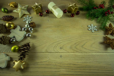 Christmas decoration on a rustic wooden board with cinnamon star, candles, christmas ballsの写真素材