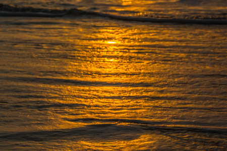 Beach with small waves on the Atlantic Ocean at sunsetの写真素材