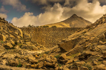 View on a historic dam and the big mountains in the backgroundの写真素材