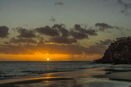 Sunset on the Atlantic coast with dark clouds and little wavesの写真素材