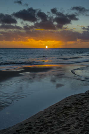 Sunset on the Atlantic coast with dark clouds and little wavesの写真素材