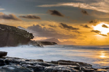 sunshine on the Atlantic Ocean with big rocks and big waves - long exposureの写真素材