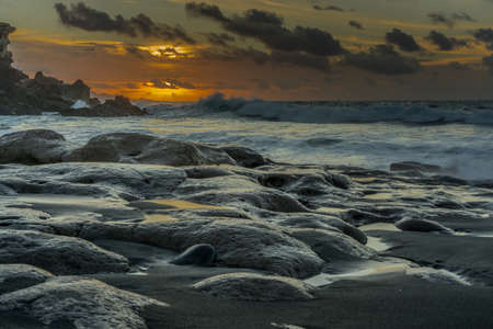 Sunshine on the Atlantic Ocean with big rocks and big wavesの写真素材