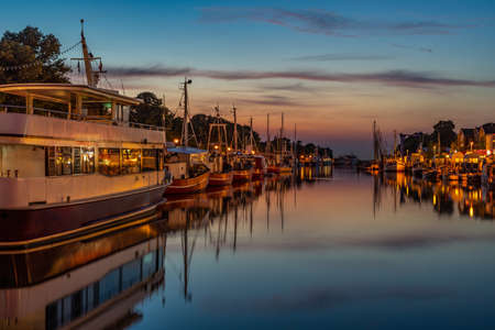 A harbor with many small boats at night as a long exposureの写真素材