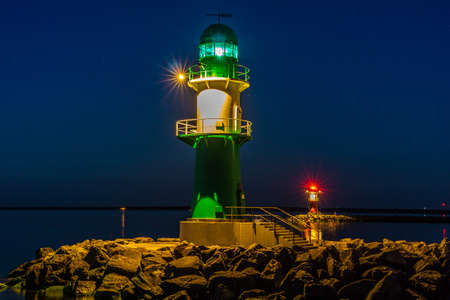 Two lighthouses at night one green and the other redの写真素材