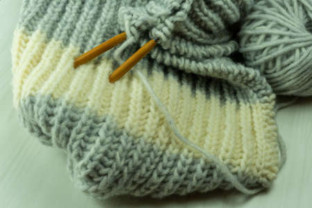 Knitted from a gray yarn and a thread for knitting close-up. Knitting as a hobby. Accessories for knittingの写真素材