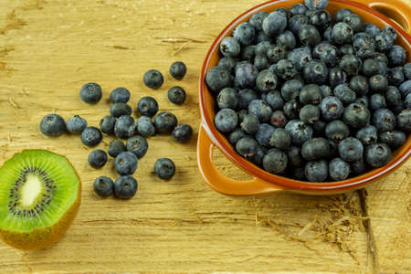 Blueberry on rustic wooden board. Blueberries in brown bowl, blue berry detailの写真素材