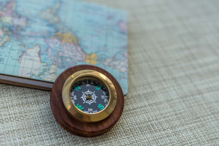 A wooden compass with a small map. Background is slightly blurry.の写真素材