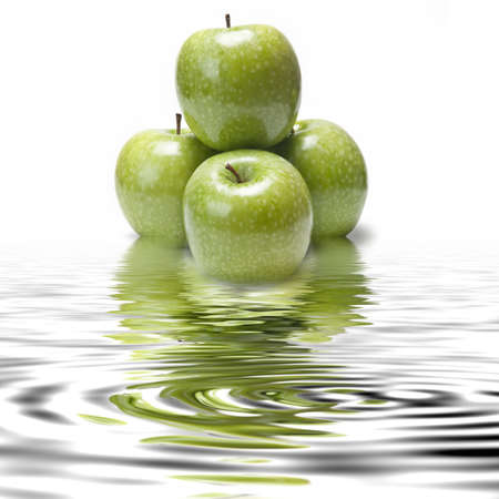 Fresh smith apples reflected on water on a white background.の写真素材