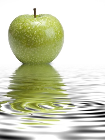 Fresh smith apple reflected on water on a white background.の写真素材