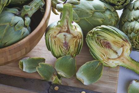 Fresh artichokes on the table of the kitchen to be cookedの写真素材