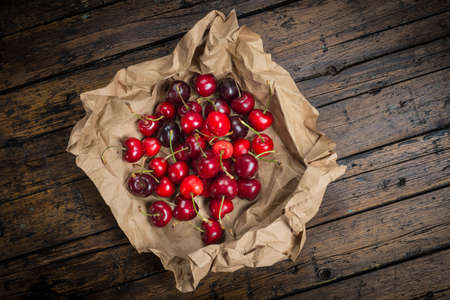 A wrapping paper with cherries on an old wooden tableの写真素材