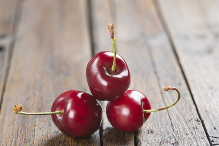 Fresh cherries on an old wooden tableの写真素材
