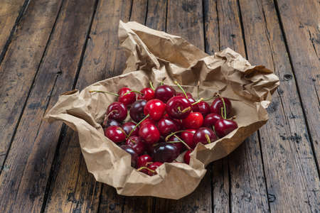 A wrapping paper with cherries on an old wooden tableの写真素材
