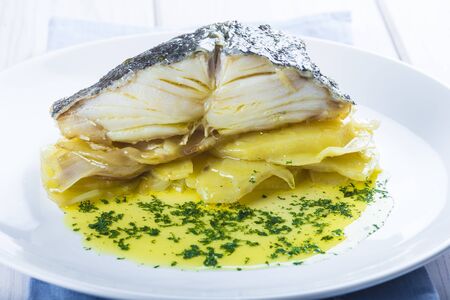 Salted cod fish oven baked with potatoes onion and olive oil