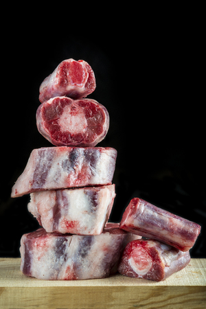 Fresh and raw oxtail cut on the cutting board isolated on a black backgroundの写真素材