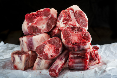 Fresh and raw oxtail cut on the cutting board isolated on a black backgroundの写真素材