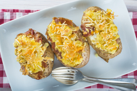 Twice baked potatoes stuffed with meat, jam, cheese and eggの写真素材