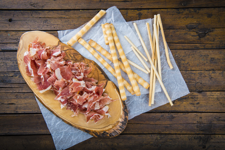 Serrano ham slices and crispy breadsticks with olive oil and tomato for breakfastの写真素材