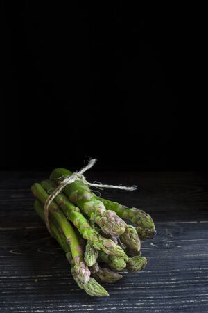 Bunch of wild green asparagus on a black backgroundの写真素材