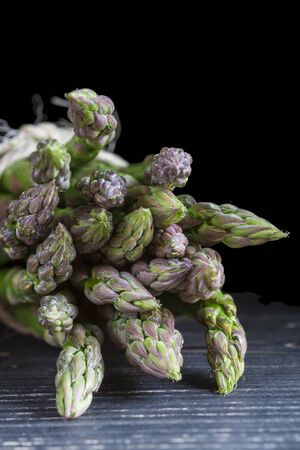 Bunch of wild green asparagus on a black backgroundの写真素材