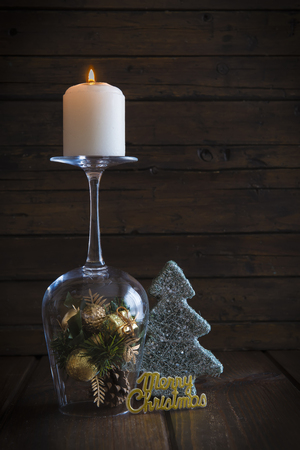 Christmas background with a candle on a cup and decoration itemsの写真素材