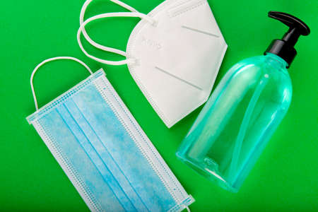 Face mask and hydroalcoholic gel to protect againts covid 19 coronavirus on green backgroundの写真素材