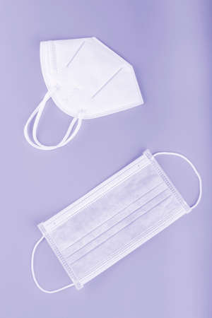 KN95 and surgical face mask to prevent covid 19 coronavirus on blue backgroundの写真素材
