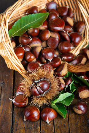 Chestnut with leaves on a wooden backgroundの写真素材