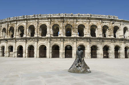 Nimes, Gard, France-April 10, 2011: Ancient arenas and a bullfighter statueの写真素材