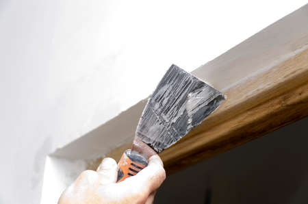 mason hand applying plaster with a spatula