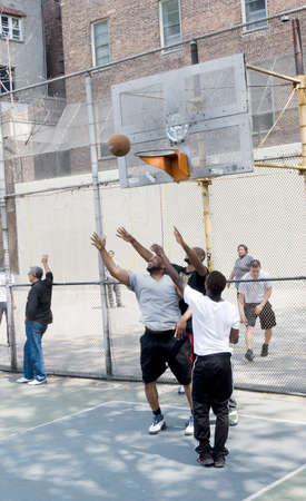 New-York City, USA - May 04, 2015: young men in action playing basketball in the street