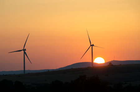 wind turbine and sun on sunset, renewable energy