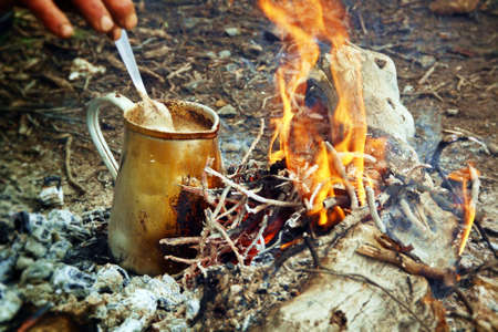 Jug of milk with soluble coffee on a campfire.