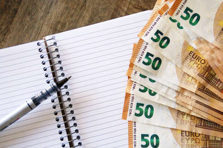 Banknotes of 50 euros and a notebook.の写真素材