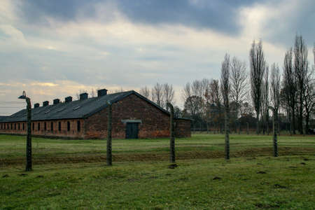 Auschwitz-Birkenau concentration camp. Electrified fence and barracks of the prisoners of the concentration camp.のeditorial素材