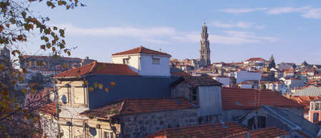 Panoramic view of Porto (Portugal) where the famous Clérigos tower stands out between the roofs of...