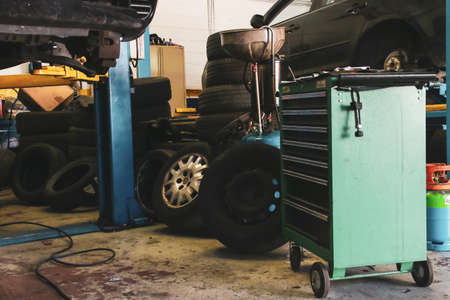Car under repair in a mechanical workshop. Car in an elevator without wheels being repaired by a mechanic.の写真素材