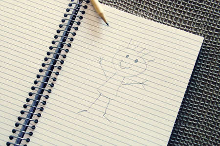 Drawing of a doodle (stick figure) in a notebook.