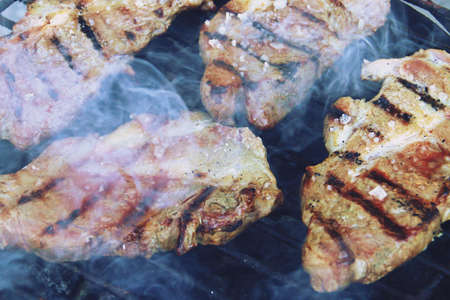 Grilling Iberian pork steaks on a barbecue with charcoal. BBQ.の写真素材