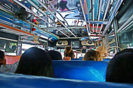 People sitting on a Thai bus with ceiling fans to cool off. Kanchanaburi, Thailand.の写真素材
